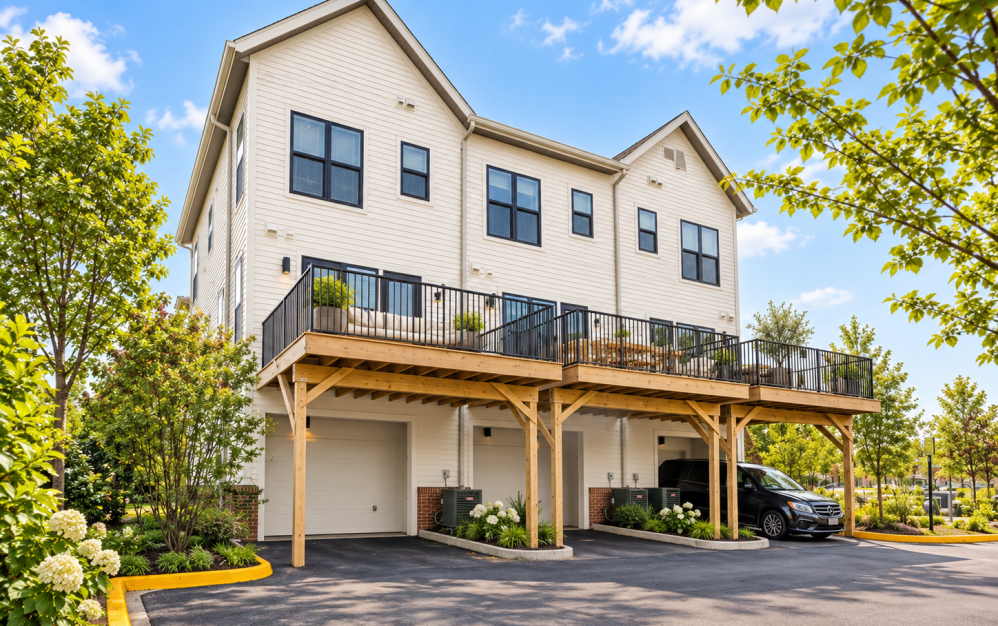 Exterior of townhome-style residences at Alta NOVA in Falls Church, VA, featuring modern architecture, elevated private decks, black metal railings, and covered parking.