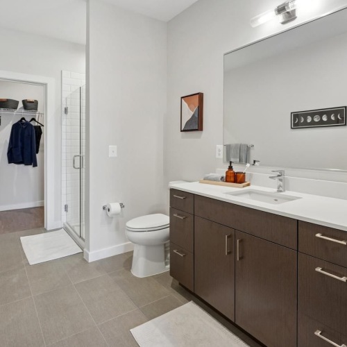 a spacious bathroom with a large mirror and ample light