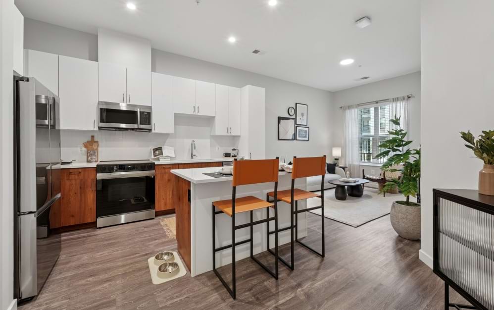 Modern kitchen in the A8 apartment at Alta NOVA featuring a large island with seating, stainless steel appliances, ample cabinetry, and an open layout.