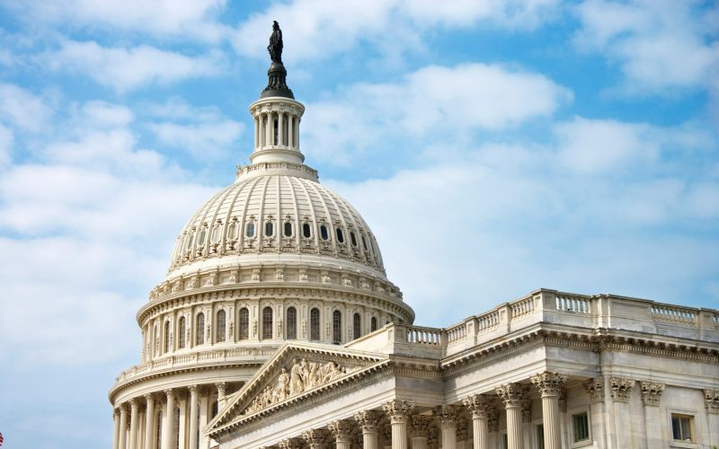 The U.S. Capitol building with its iconic dome under a partly cloudy sky sits majestically, not far from the modern elegance of Alta Nova apartments.