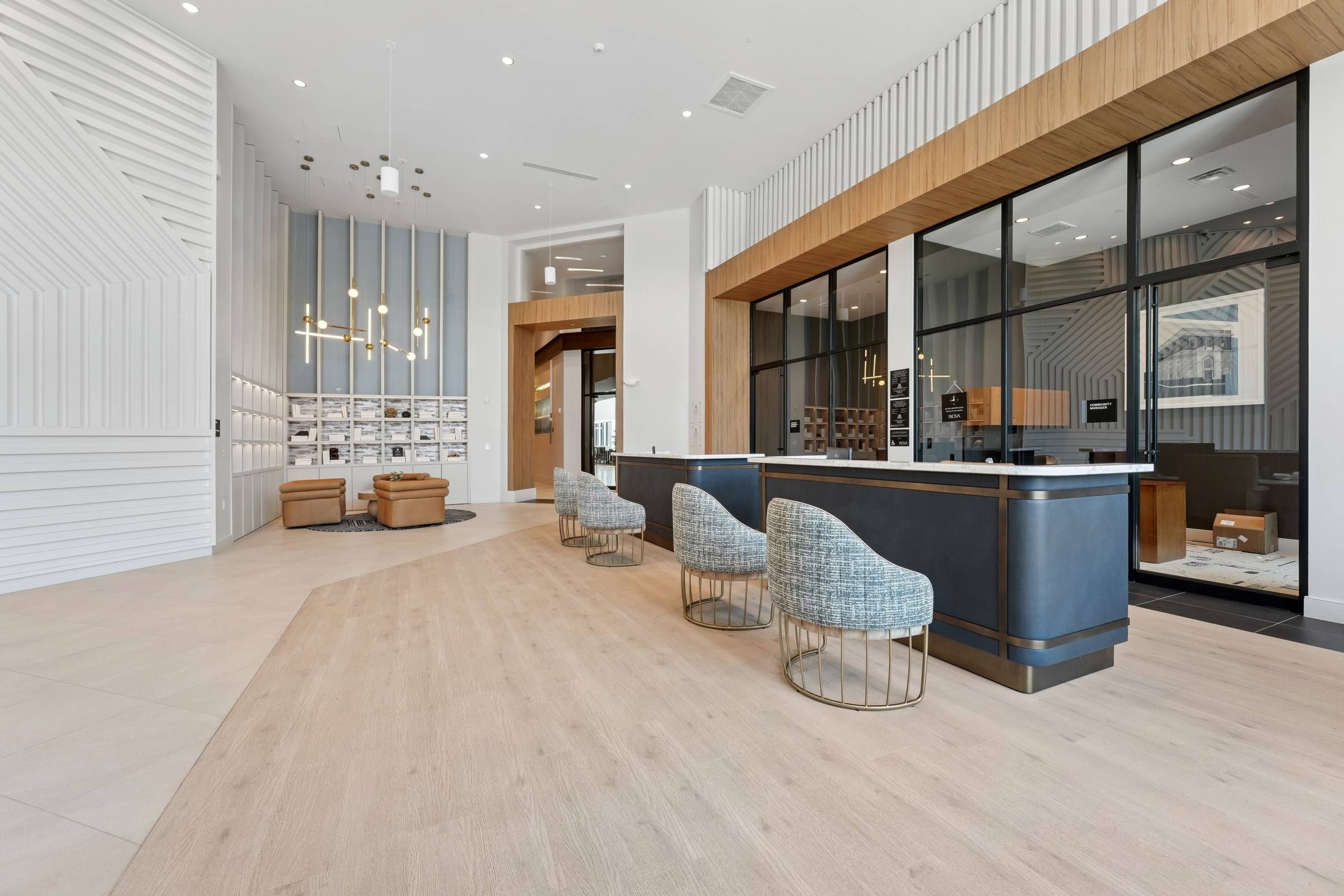 Alta Nova apartments Modern office lobby with sleek counters, stylish chairs, lounge seating, and floor-to-ceiling windows.